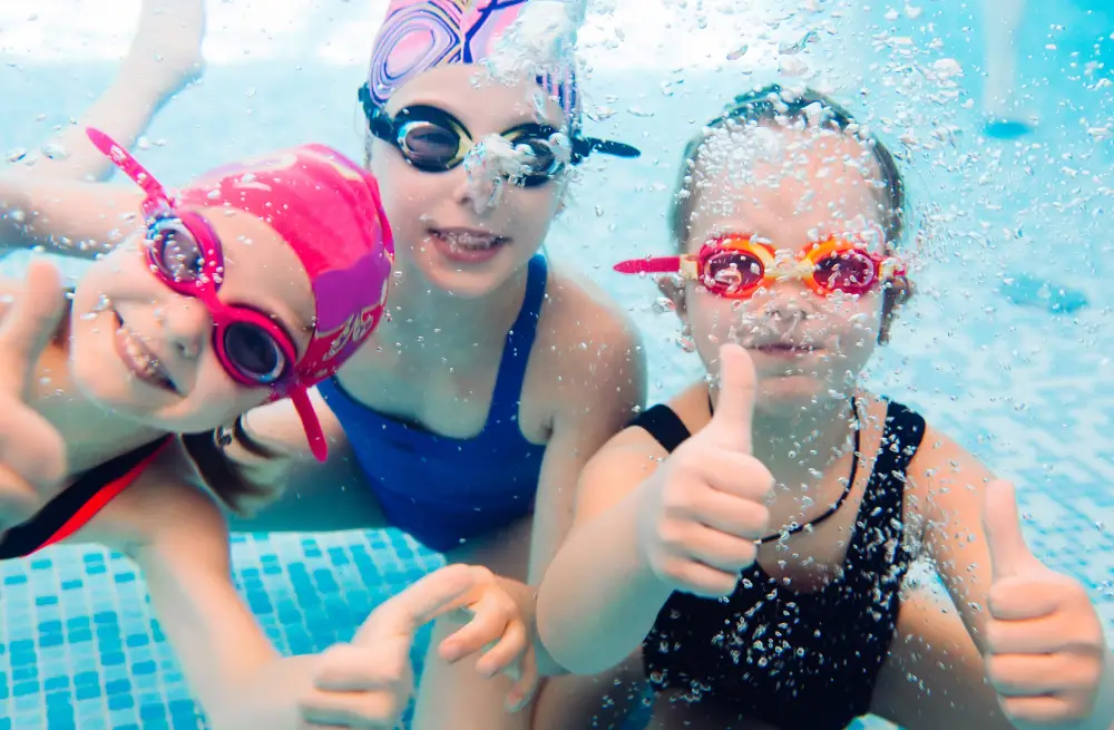 Join the Swim Squad – Where Fun Meets Growth! Underwater photo of young friends in swimming pool