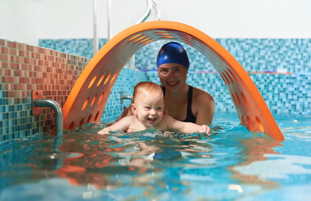 Mini Star 3_ 20 months - 36 months Playful active training in swimming pool. Little cute boy is learning how to float with his supportive mother. Concept of healthy family