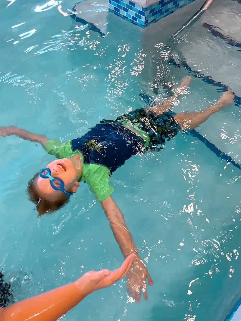 Group classes - star 3 a boy is learning how to swim with a bathing strap